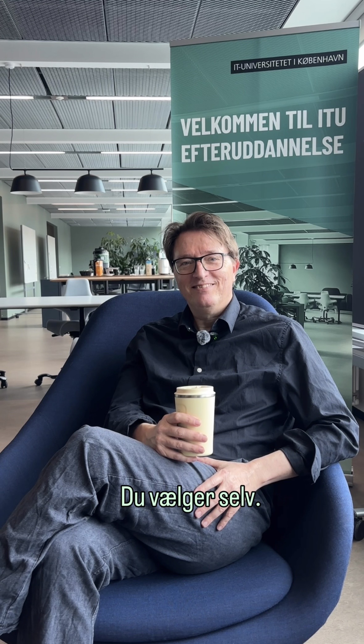 Underviser i en stol med kop.
